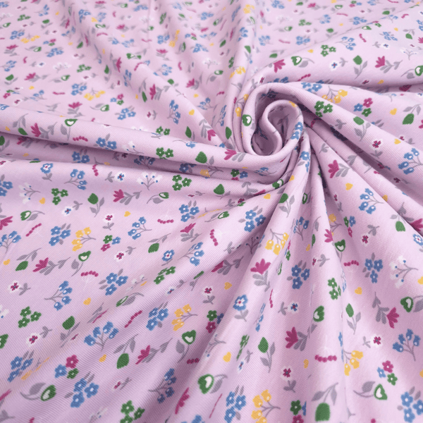 Baumwolljersey – MEHRFARBIGE BLUMEN MIT ROSA HINTERGRUND – Mindestzuschnitt oder Vielfaches von 25 x 140 cm