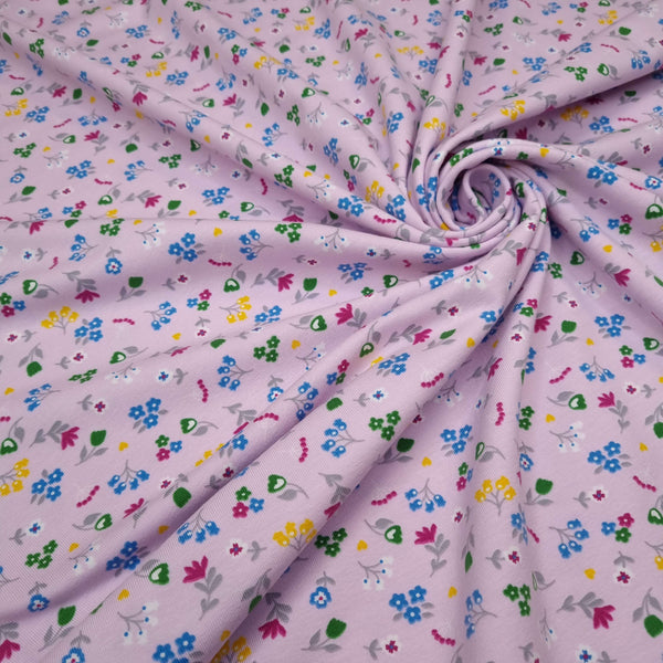 Baumwolljersey – MEHRFARBIGE BLUMEN MIT ROSA HINTERGRUND – Mindestzuschnitt oder Vielfaches von 25 x 140 cm